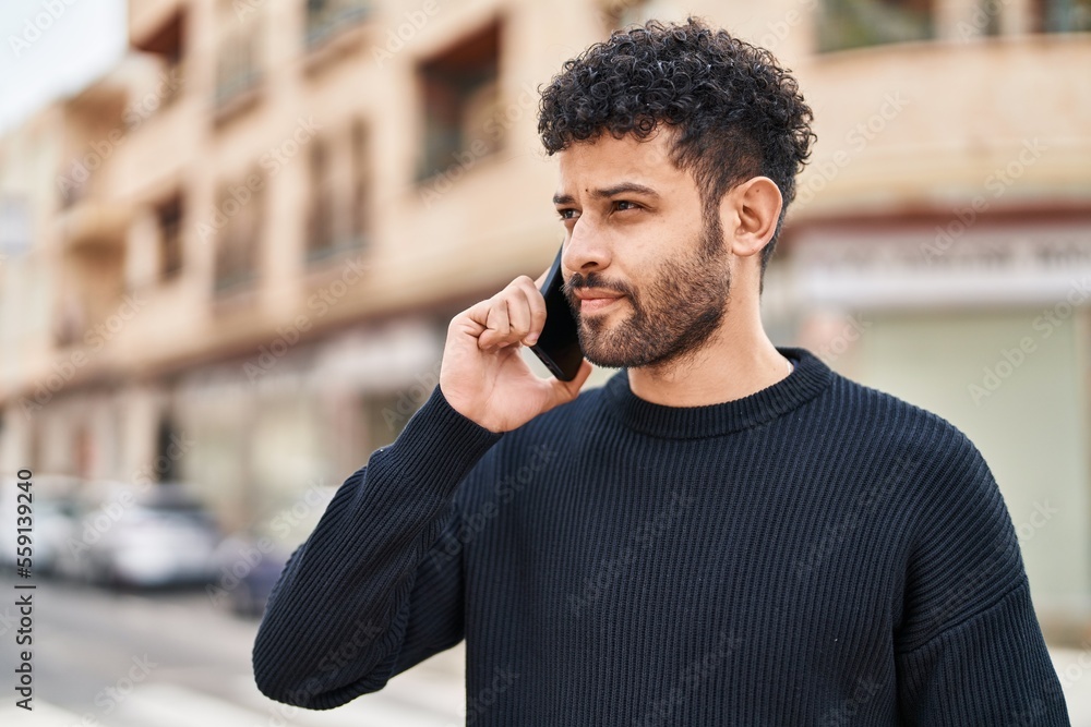 © Krakenimages.com - Young arab man smiling confident talking on the smartphone at street