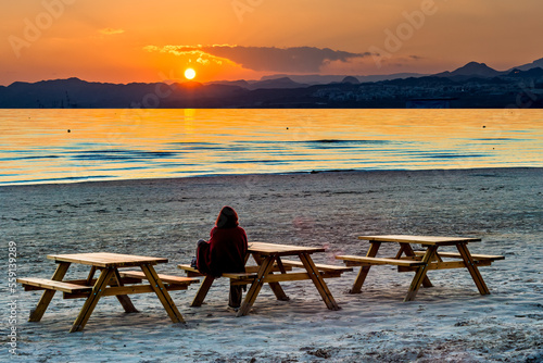 Coastal landscape with silhouette of resting and happy woman