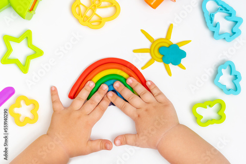 Child hands playing with colorful plastiline. Girl molding modeling play dough.