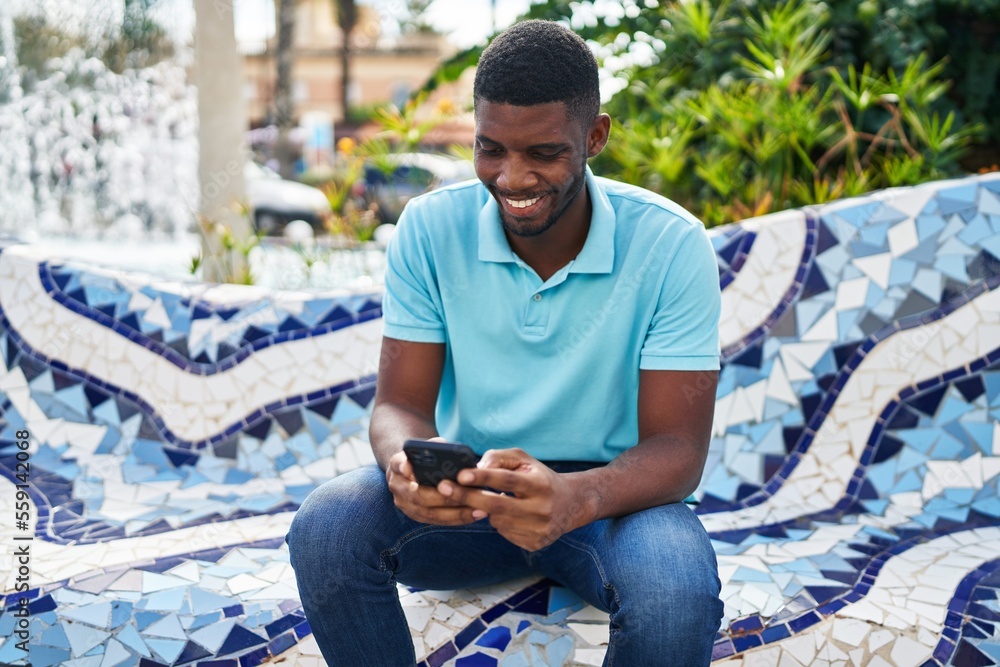 Obraz premium Young african american man smiling confident using smartphone at park