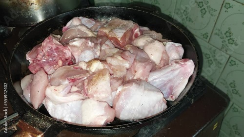 Cooking chopped chicken with an ax in a pan