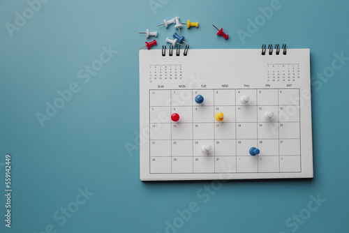Embroidered red pins on a calendar event Planner calendar,clock to set timetable organize schedule,planning for business meeting or travel planning concept. 