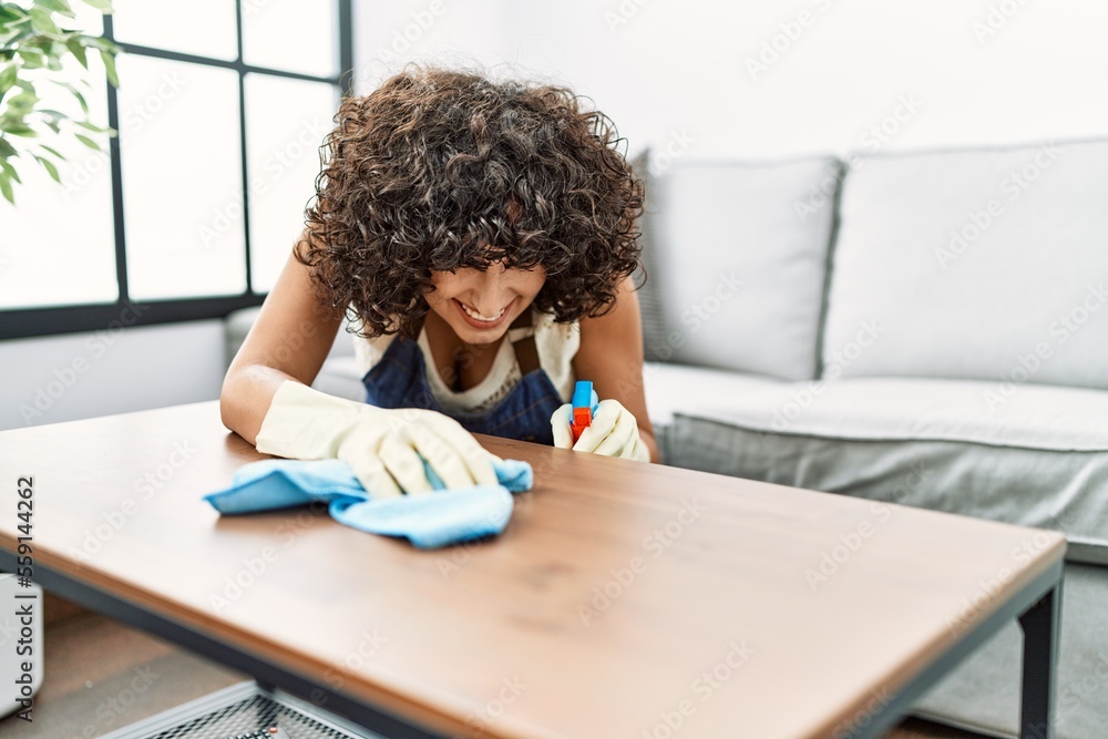 Young middle east woman smiling condident cleaning table at home Young middle east woman smiling condident cleaning table at home