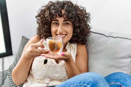Young middle east woman smiling confident drinking tea at home photo