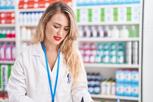 Free Download Young beautiful hispanic woman pharmacist standing with serious expression at pharmacy - GFXLoad