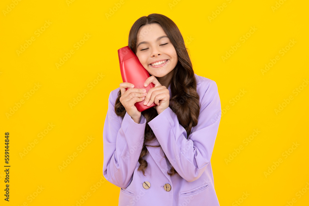 Child teen girl with shampoos conditioners and shower gel. Long hair care of teenager. Presenting cosmetic product, shampoo bottle. Shampooing hair. Child teen girl with shampoos conditioners and shower gel. Long hair care of teenager. Presenting cosmetic product, shampoo bottle. Shampooing hair.