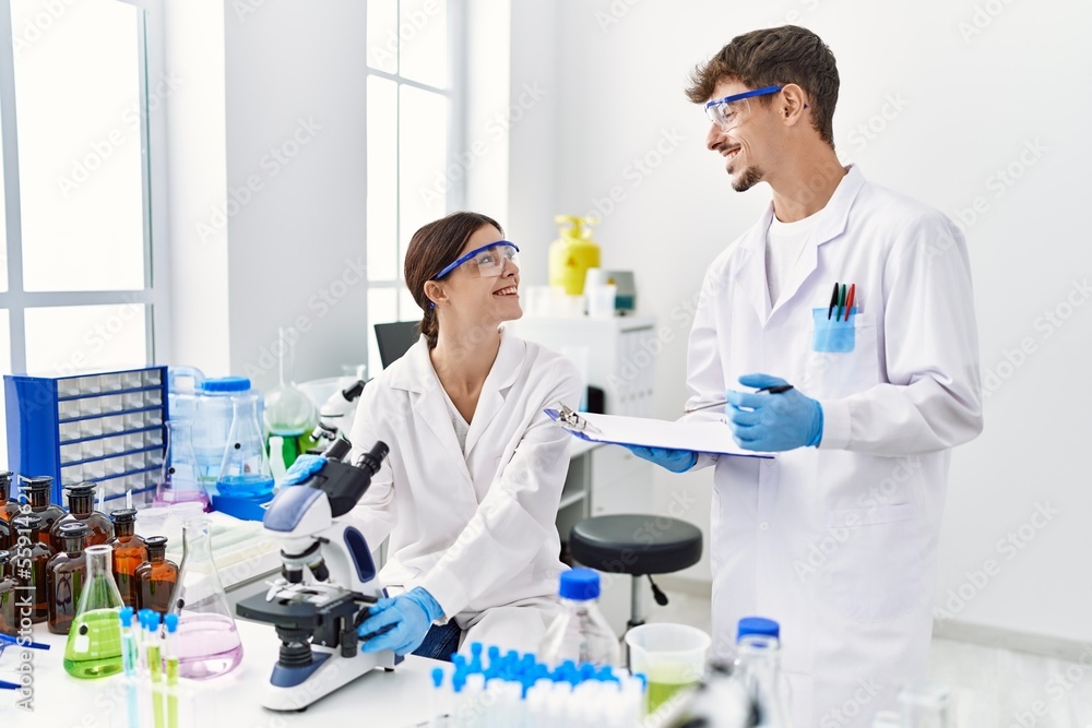 Man and woman partners wearing scientist uniform working at laboratory Man and woman partners wearing scientist uniform working at laboratory