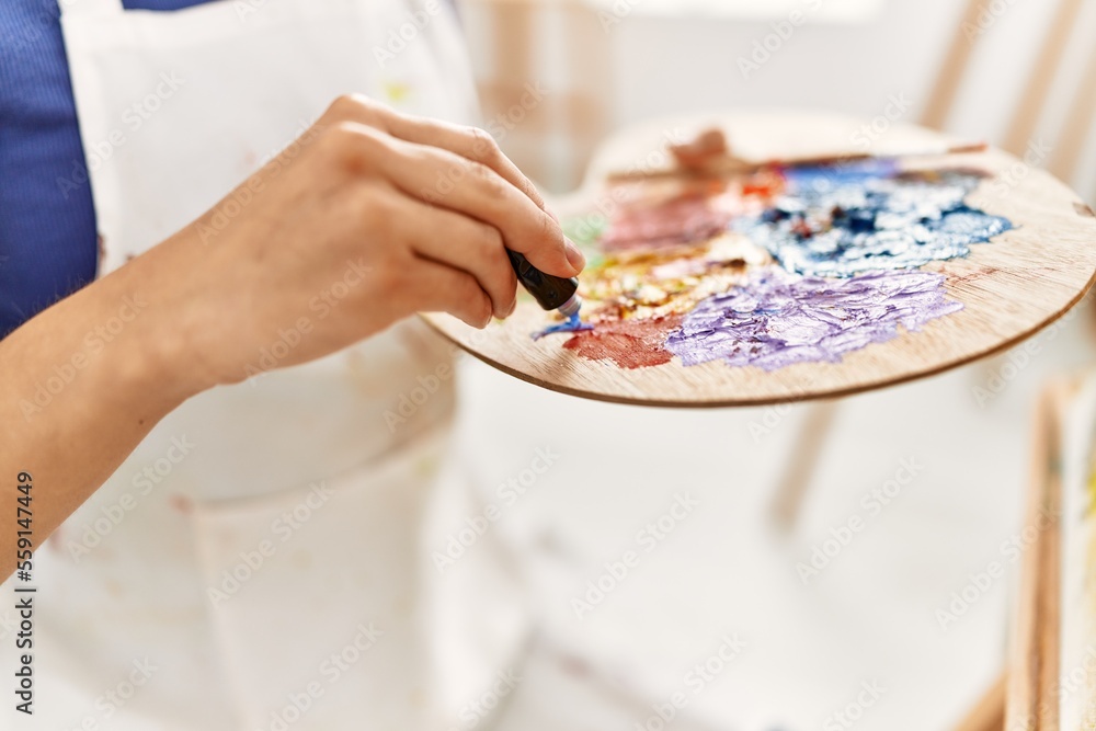 Young latin woman mixing color on palette at art studio Young latin woman mixing color on palette at art studio