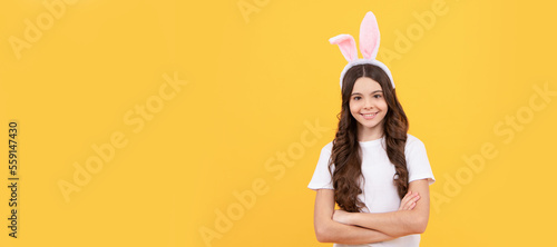cheerful child in bunny ears on yellow background. Easter child horizontal poster. Web banner header of bunny kid, copy space.