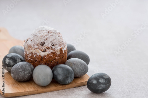 Stylish grey Easter eggs in marble and concrete and a cake on a wooden stand. Coloring eggs with natural dye karkade tea. Environmental friendliness. Naturalness. The concept of happy Easter 2023.