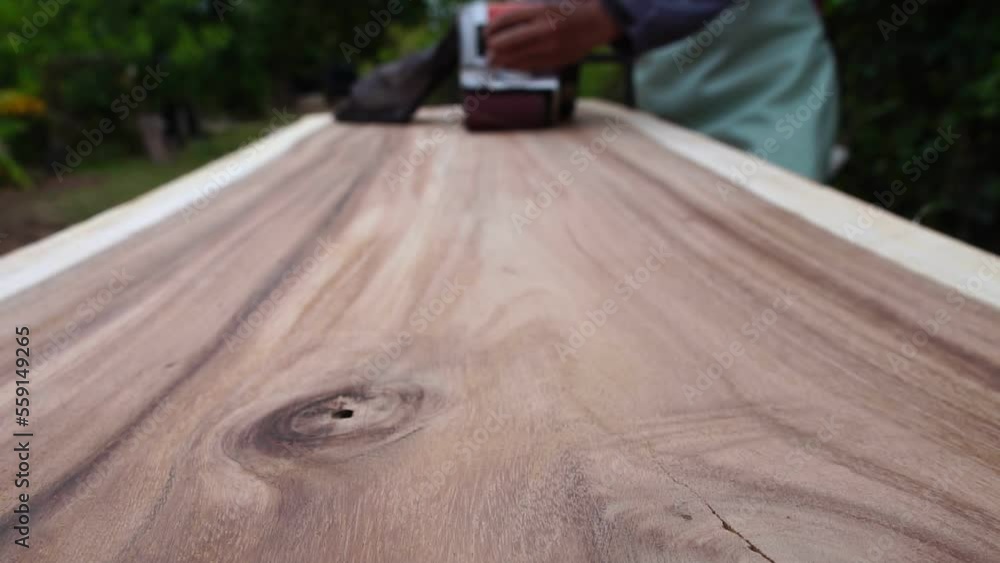 Hand of man sanding wood with orbital sander in a workshop Hand of man sanding wood with orbital sander in a workshop