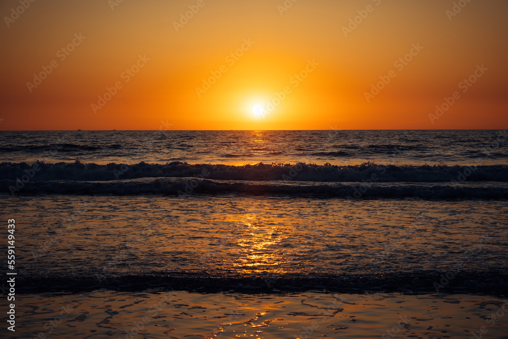 Beautiful sunset over the sea. Rays of the sun touches surface of the calm sea. Meditative atmosphere.