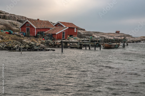 Beautiful little typical red swedish house in a long exposure directly at the sea. PORT in a bay by the sea