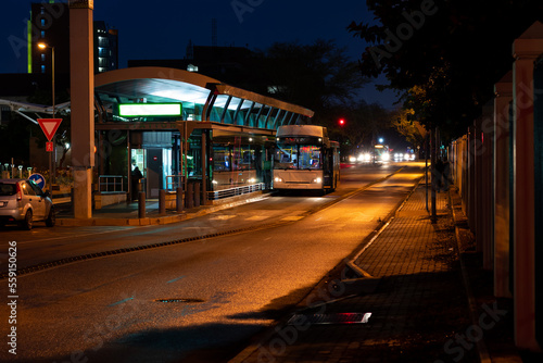 Bus parked at a bus stop at night