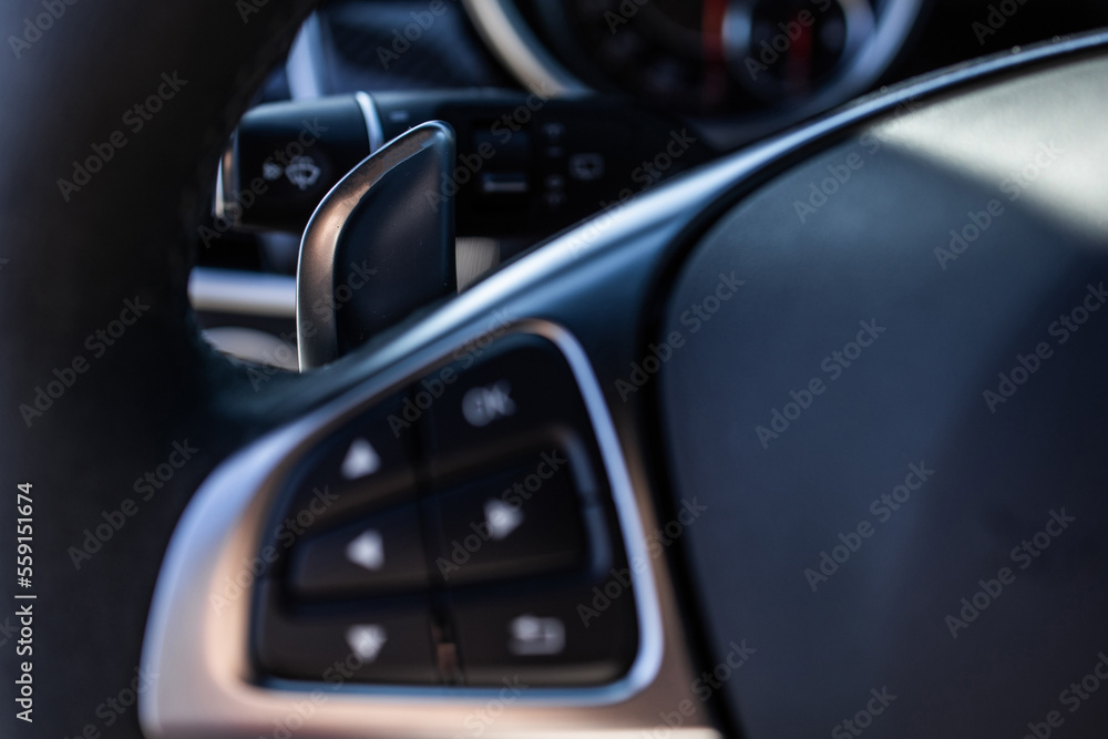 gearbox control buttons on the leather steering wheel of a premium car