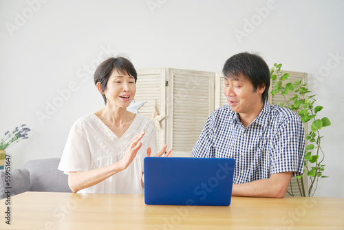  家でパソコンを使う熟年夫婦