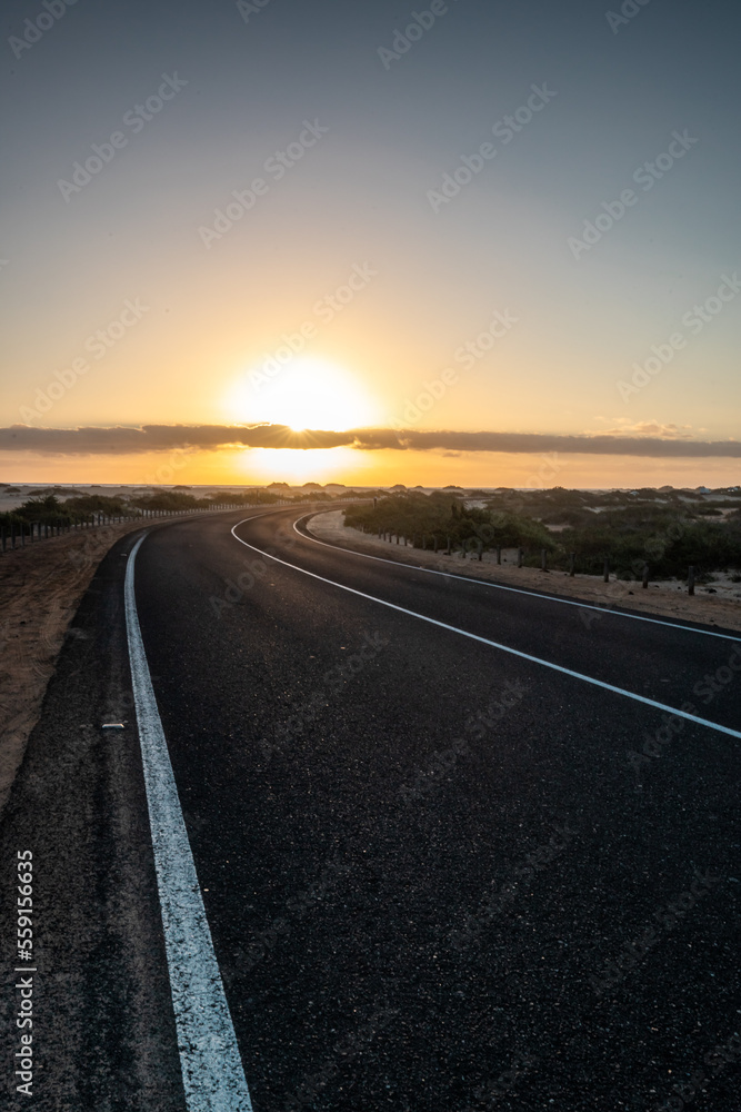 Beautiful morning on a road through the dunes. Sunrise over a road with clouds. Corralejo National Park, Canary Islands, Spain