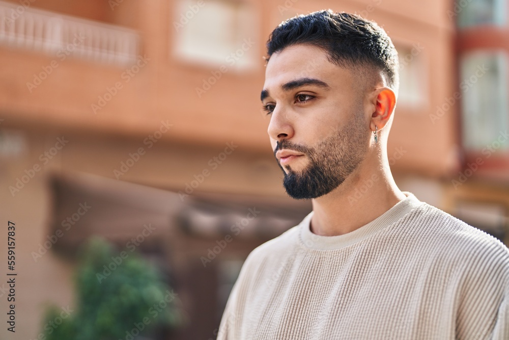 Young arab man with relaxed expression standing at street Young arab man with relaxed expression standing at street