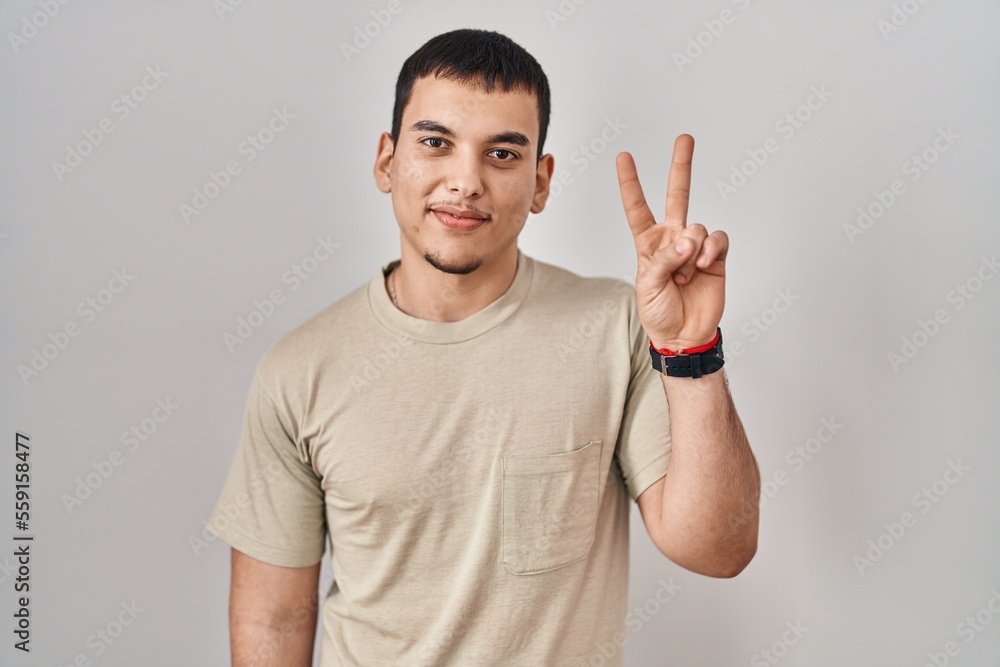 Young arab man wearing casual t shirt showing and pointing up with fingers number two while smiling confident and happy. Young arab man wearing casual t shirt showing and pointing up with fingers number two while smiling confident and happy.