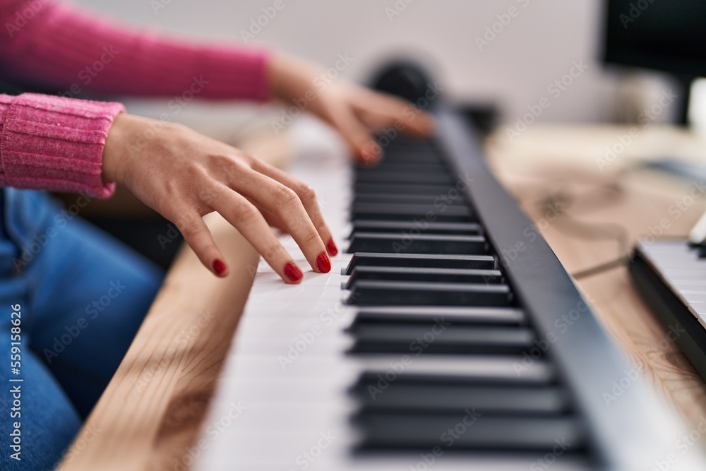 Fototapeta premium Young caucasian woman musician playing piano at music studio