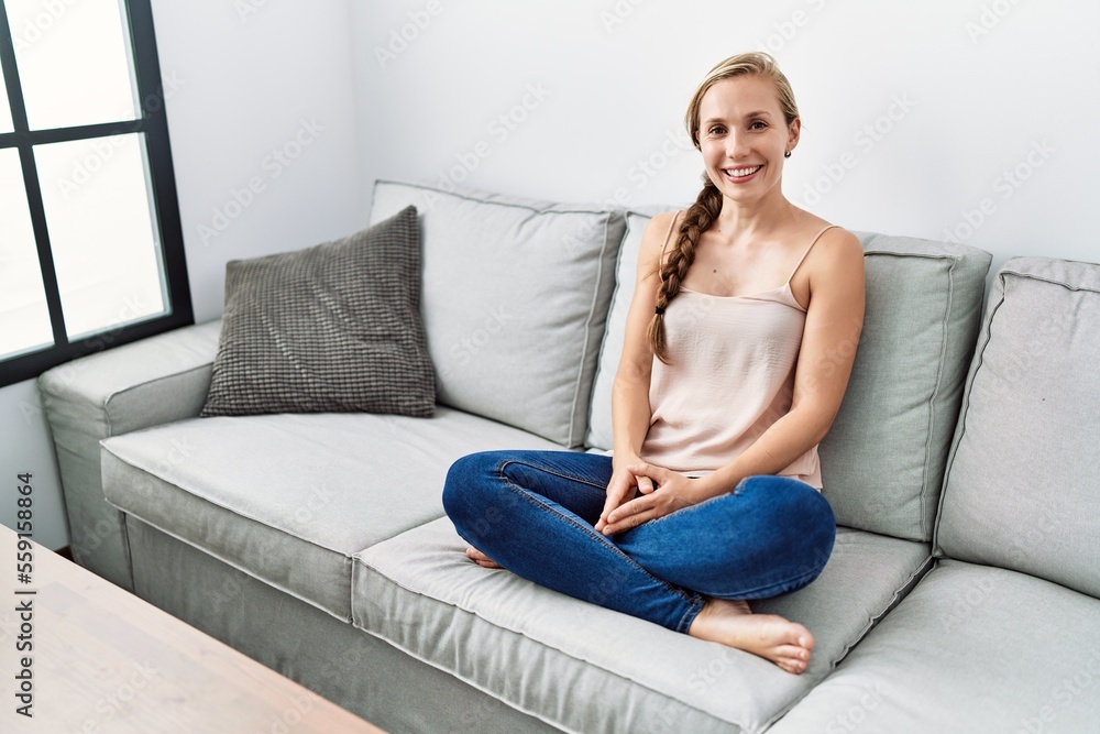 Young caucasian woman smiling confident sitting on sofa at home