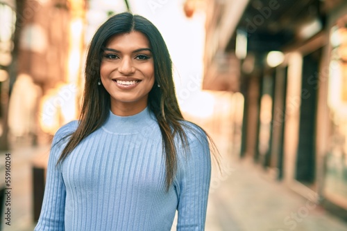 Beautiful hispanic woman smiling confient at the city photo