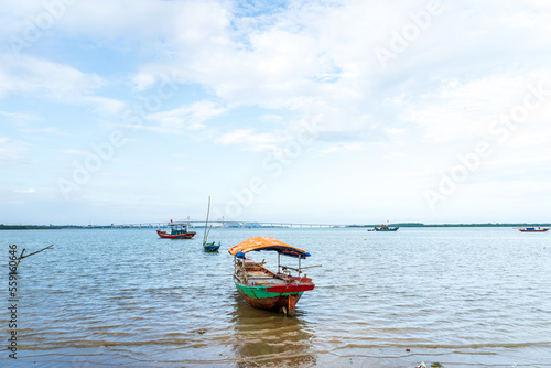 The scenery of the estuary with the bridge crossing is very beautiful, the sky is clear and the small boats are ready to go fishing