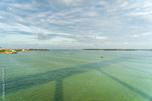 The scenery of the estuary with the bridge crossing is very beautiful, the sky is clear and the small boats are ready to go fishing