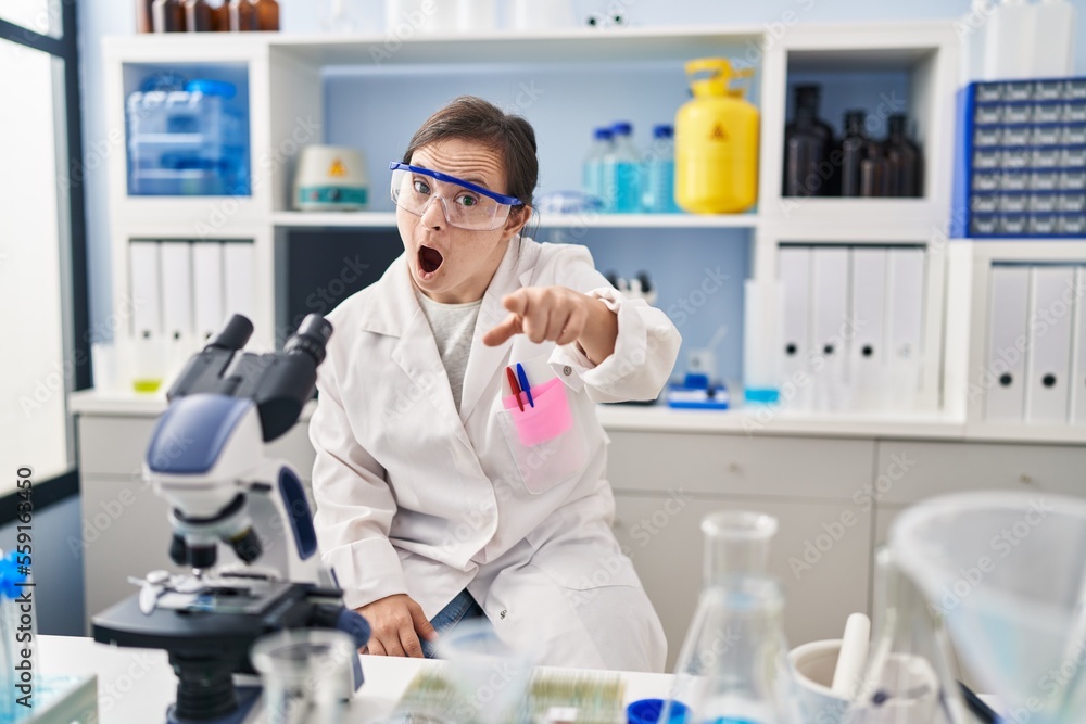 Hispanic girl with down syndrome working at scientist laboratory pointing displeased and frustrated to the camera, angry and furious with you Hispanic girl with down syndrome working at scientist laboratory pointing displeased and frustrated to the camera, angry and furious with you