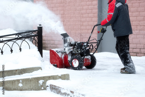 A portable snow blower powered by gasoline. Snow removal in winter.