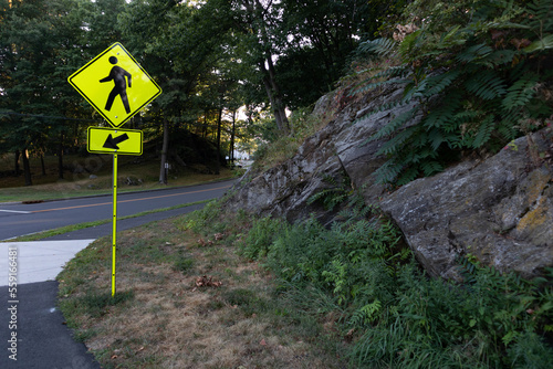 Pedestrian Crossing Sign along a Rural Road with Rock Formations and Green Trees in Greenwich Connecticut