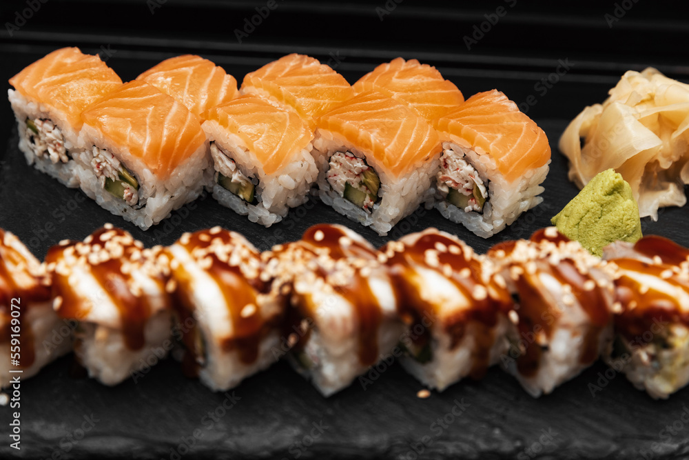 Sushi on a stone plate with black background Sushi on a stone plate with black background