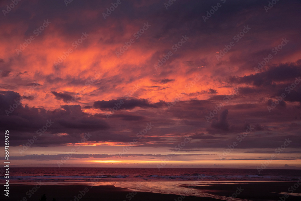 Sunset at beach and coast of Glinks Gully, kust, new zealand. Red skies.