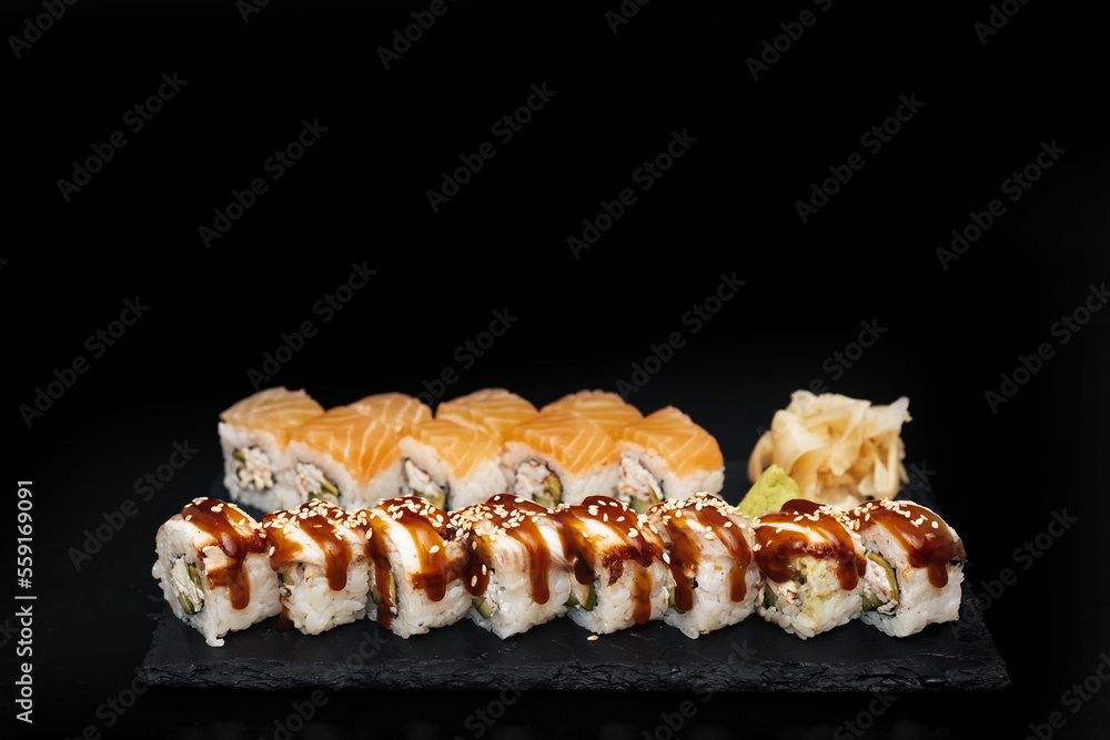 Sushi on a stone plate with black background Sushi on a stone plate with black background
