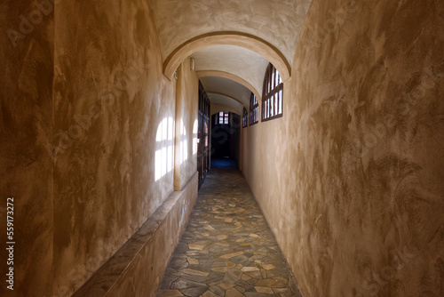 corridor of a monastery with light projected onto the walls from the windows