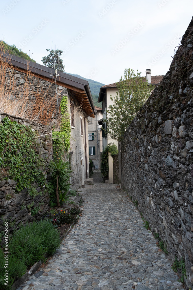 Lecco, Italy - April, 29, 2022: Very narrow streets between buildings in Italian mountain. Medieval village of Corenno Plinio.