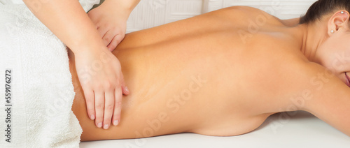 Girl getting back massage in massage salon, health spa