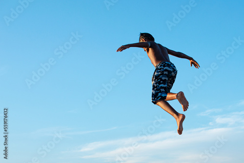 This is a photograph taken by me, on an old bridge that is in the city where I live. This boy is jumping off this bridge towards the sea.