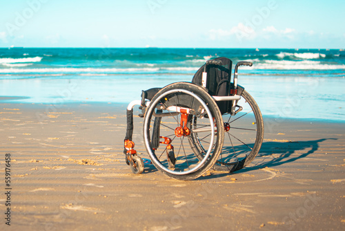 Photograph of a wheelchair on the beach, bringing a reflection