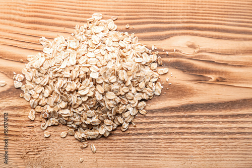 Rolled oat flakes on rustic...