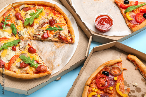 Cardboard boxes with tasty pizza on color background  closeup