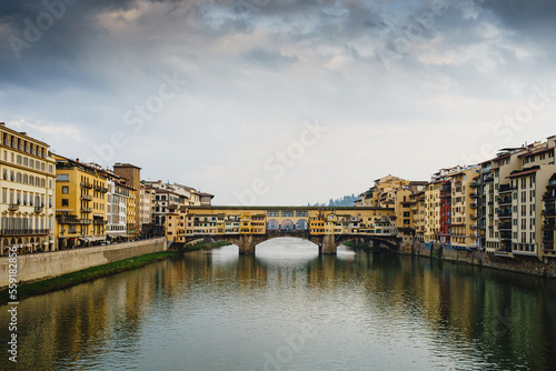 Panoramic view of the Ponto Vecchio Bridge and the Arno River in Florence. Reflection in the water of buildings and roofs of houses. Fog  Perspective  typical Tuscan landscape