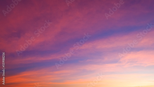 Beautiful romantic orange sunset clouds with yellow sunlight on dusk sky twilight background