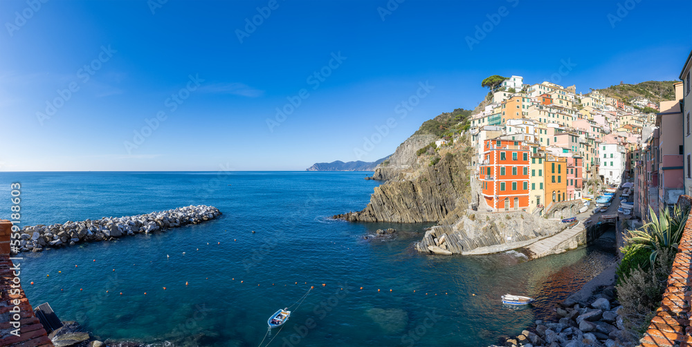 Boats in marina and colorful apartment homes in touristic town, Riomaggiore, Italy. Cinque Terre National Park. Panorama