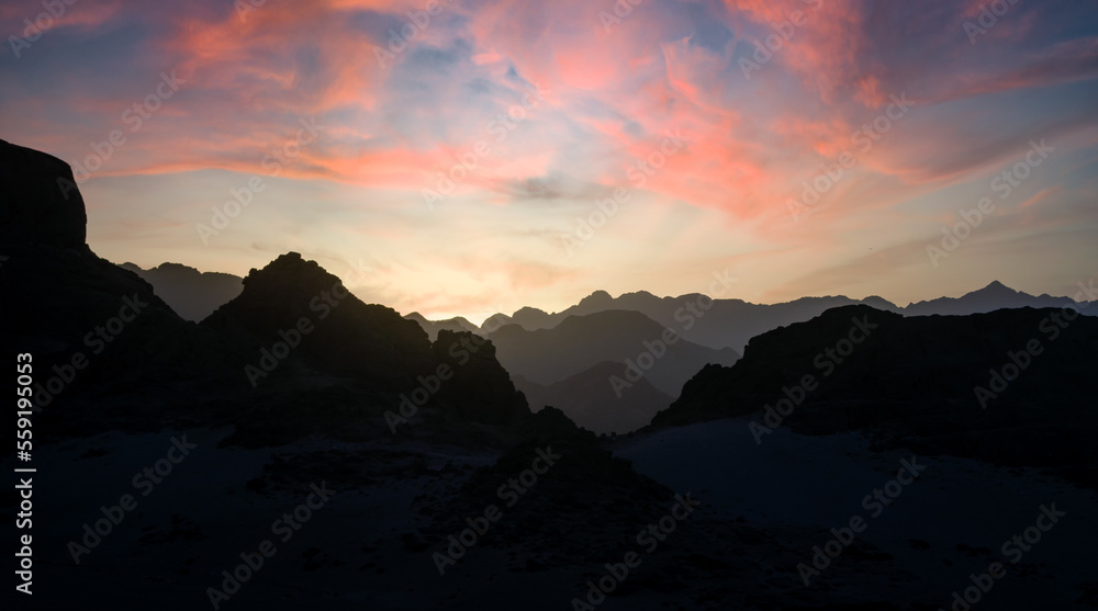 peaks of mountains in the desert against sunset