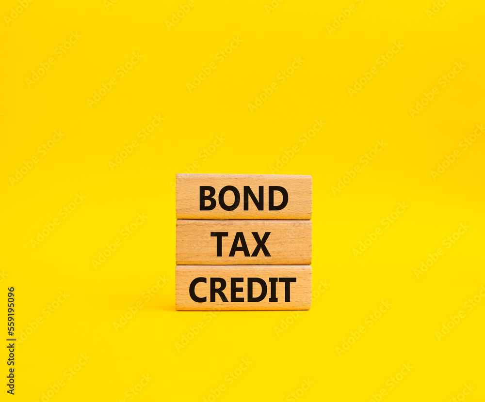 Bond Tax Credit symbol. Concept word Bond Tax Credit on wooden blocks. Beautiful yellow background. Business and Bond Tax Credit concept. Copy space Bond Tax Credit symbol. Concept word Bond Tax Credit on wooden blocks. Beautiful yellow background. Business and Bond Tax Credit concept. Copy space