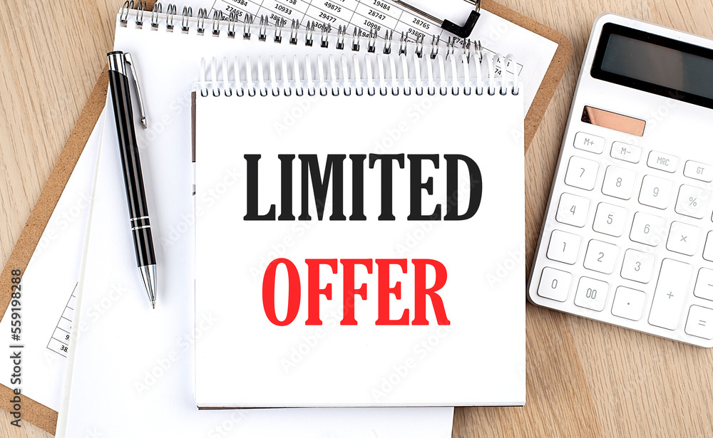 LIMITED OFFER is written in white notepad near a calculator, clipboard and pen. Business concept LIMITED OFFER is written in white notepad near a calculator, clipboard and pen. Business concept