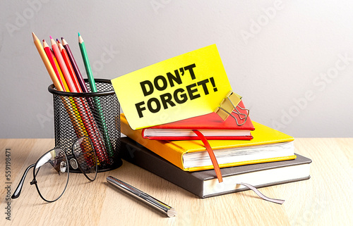 DON'T FORGET written on a sticky on notebooks photo