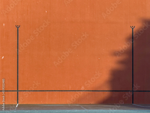 red wall of a Basque pelota fronton in France. with the black stripes drawn. photo