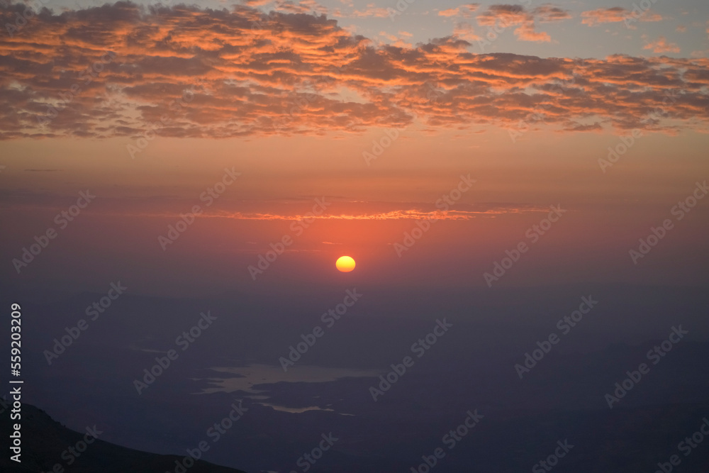Sunrise view of mount nemrut, the sun cames up from east behind the mountains and lake and colorful clouds make the view better